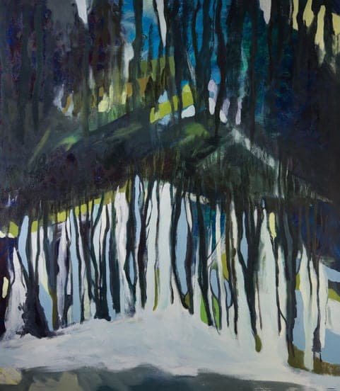 A dark stand of trees mirrored over pale water.